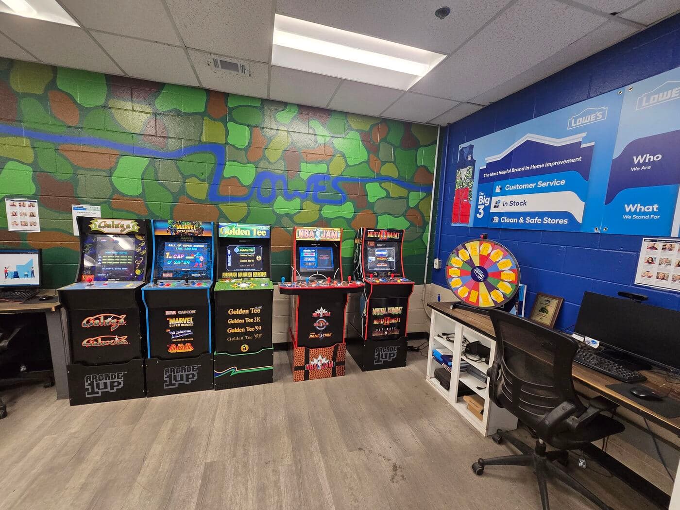 Arcade cabinets including Galaga, Marvel Super Heroes, Golden Tee, NBA Jam, and Mortal Kombat set up in the Lowe's employee break room in Goshen, Indiana
